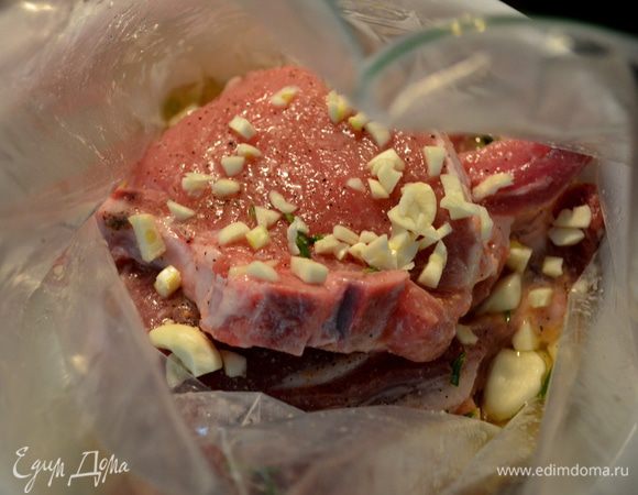 Добавим в пакет свин.отбивные ,сверху выложим порезанный чеснок и чеснок дольками.Закроем пакет и поставим в холодильник на ночь.