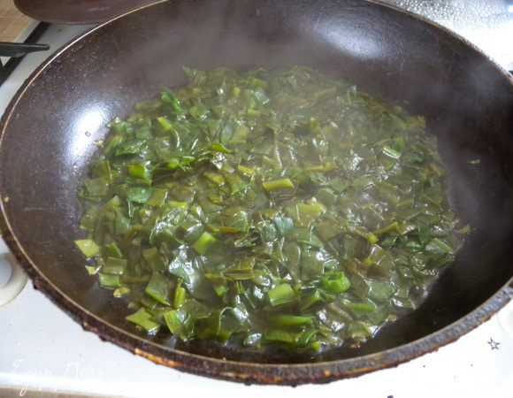 Всыпать на горячую сковородку и накрыть крышкой. Подердать так 2 минуты. Листья очень мясистые  и без этого они потом будут хрустеть. 