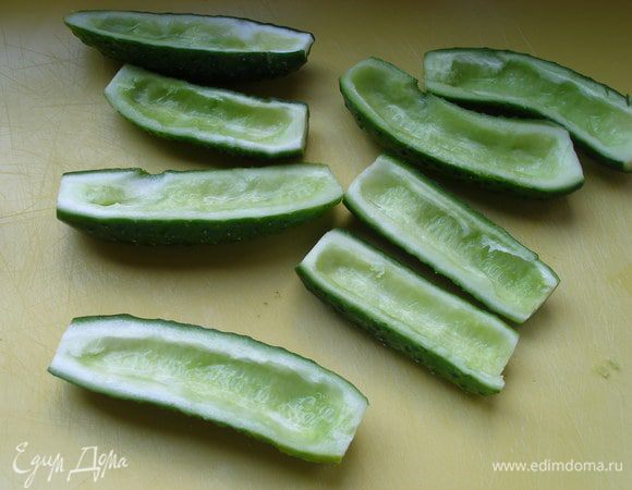 Огурцы помыть, разрезать вдоль и удалить семена.