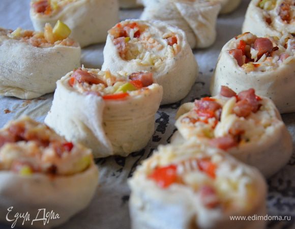 Свернуть в рулет и разрезать на кусочки,в длину около 7-8см.Защипать с одной стороны тесто,чтоб начинка не выпала.Поставить на противень застеленный пергаментом защипанной стороной вниз,слегка придавить верх.Присыпать оставшимся сыром.