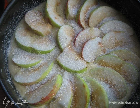 Форму смазываем маслом и присыпаем сахаром. Выливаем тесто. Сверху выкладываем нарезанное яблоко, посыпаем сахаром.