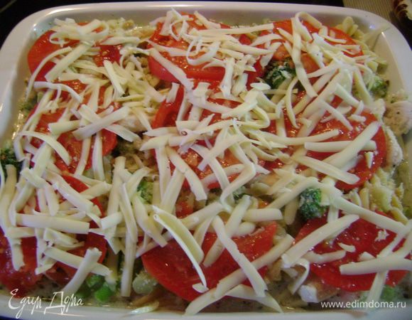 Выложить смесь в огнеупорное блюдо. Обсыпать толчеными сухарями, уложить сверху помидор, нарезанный тонкими дольками, и посыпать тертым сыром.