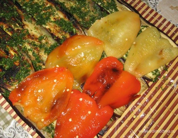 Выложите на баклажаны рубленую зелень с чесноком, а сверху - поперек - половинки перцев на всю длину рулета (оставив сантиметров 5 в конце свободными для удобства сворачивания) и тоже хорошо посолите и поперчите.