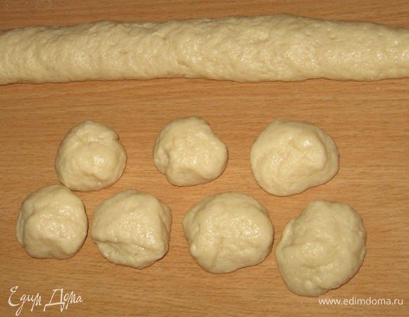 Делим шар теста на две части, формируем 2 колбаски и делим каждую на 6 или 7 частей. 
Сразу подготовьте противень, на котором будете выпекать пирожки и застелите его пергаментом. Ничем не смазывайте - тесто маслянистое - не прилипнет (проверено) :)