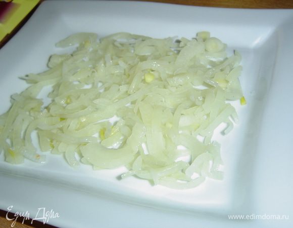 Лук чистим, нарезаем полукольцами, ошпариваем горячей водой. Затем отжимаем и выкладываем на тарелку, это будет первый слой нашего салата. Смешиваем сметану и майонез в пропорции 2:1, по желанию добавляем соль и перец. Этой смесью смазываем луковый слой.
