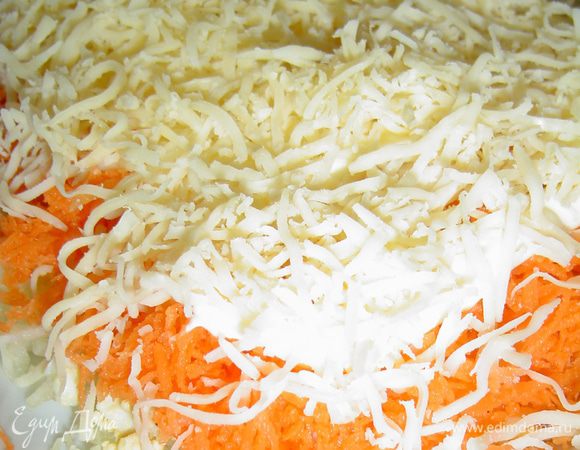 Пятым слоем будет сыр, который натираем на мелкой терке и выкладываем на морковь и опять смазываем соусом.