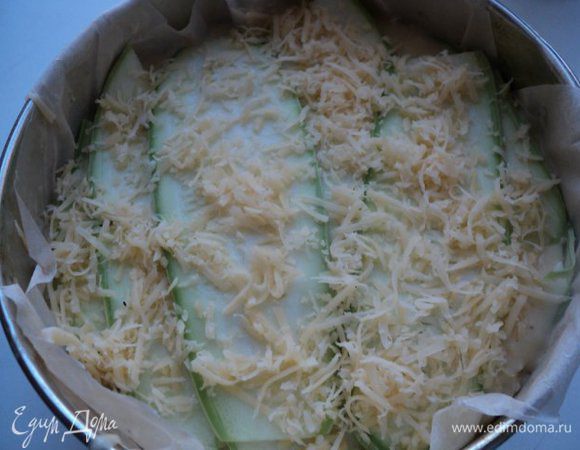 Снова выложить слой кабачков, укладывая их перпендикулярно нижнего слоя. Затем сыр, базилик, соус и так далее. Сверху посыпать оставшимся сыром.