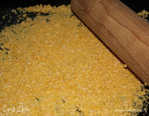 Кукурузные хлопья растолочь скалкой.