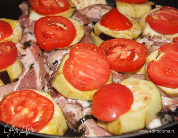 Выкладываем на противень кусочки мяса, а на них баклажаны и сверху помидоры. 