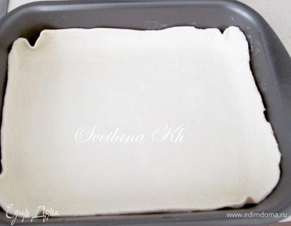 Тесто разделите на 2 равные части. Раскатайте по размеру формы. У меня продолговатая 33х22 см. Выложите один пласт теста в форму.