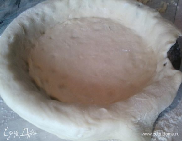 Самый большой кусок теста раскатайте в пласт и выстелите им дно формы для выпечки так,чтобы края свисали.(предварительно смажьте форму маслом).