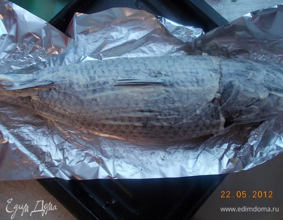На фольгу смазанную маслом, выложить рыбу. Приложить к краям голову и хвост.Смазать сметаной.