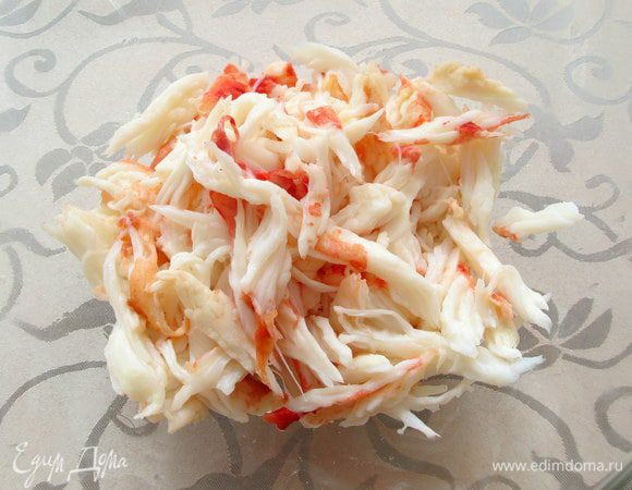 Мясо крабов разберите на небольшие кусочки . Выложите вторым слоем и смажьте майонезом.