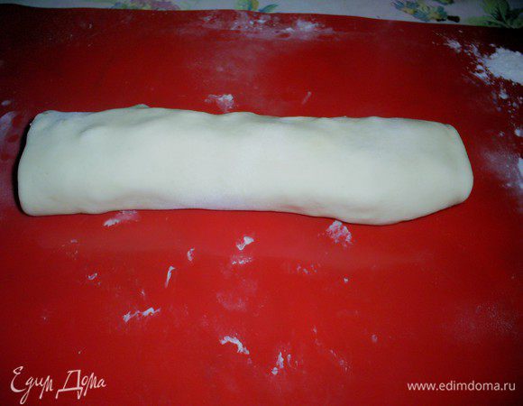 Сворачиваем тесто с начинкой рулетом.