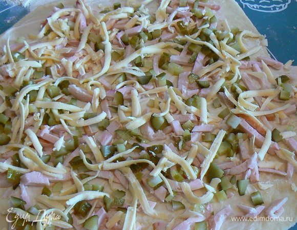 Раскатать часть теста в пласт толщиной примерно 0,5 см.

Смазпть его майонезом и выложить начинку
