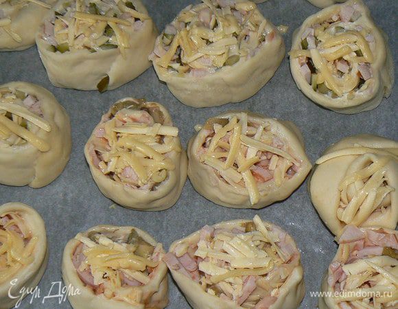 Противень выстелить пергаментной бумагой, смазать маслом. Выложить рулетики на противень и присыпать сверху сыром.

Отправитьв духовку.  Выпекаются минут 25-30 при температуре градусов 200.

