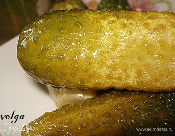 Огурцы замочить на 2-3 часа в холодной воде. Затем отрезать у огурцов попки с двух сторон. В посуду, в которой будут мариноваться, уложить листья, порезанный чеснок. Положить огурцы. У меня получилось 2 банки по 800 г. Приготовить маринад. В холодную воду положить соль, сахар и довести до кипения. Снять с плиты и добавить лимонный сок. Залить горячим рассолом огурцы. Я укладываю в банки с закручивающимися крышками. Закрыть  крышками и оставить на 12 часов в помещении, а потом можно и в холодильник.