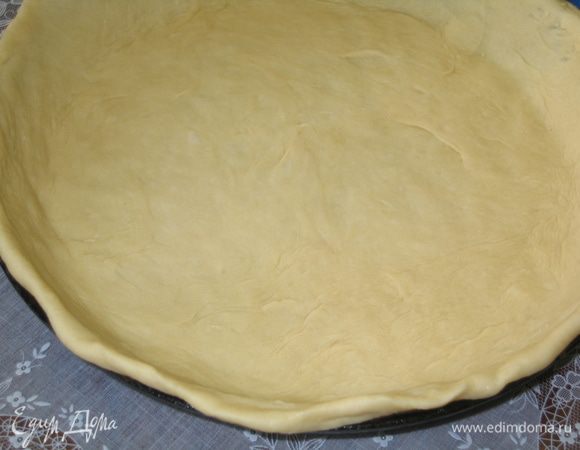 3/4 части всего теста раскатать в круг и выложить при помощи скалки на смазанную маслом форму, приподняв бортики