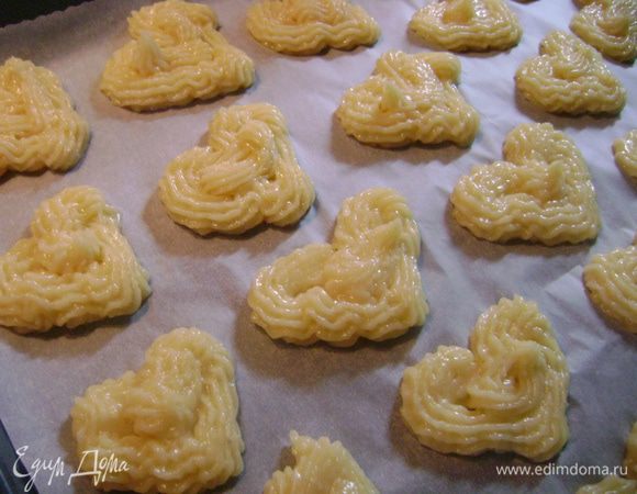 Кондитерский шприц (мешок) наполнить заварным кремом и отшприцевать на противень, застеленный пергаментной бумагой, сердечки.