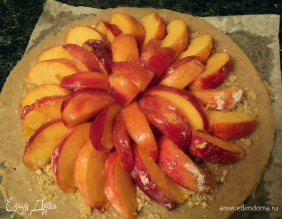 Затем, отступая от края лепешки 3 см, выложить начинку из персиков.