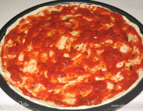 Тесто раскатать и уложить в форму. Поверхность смазать томатным соусом