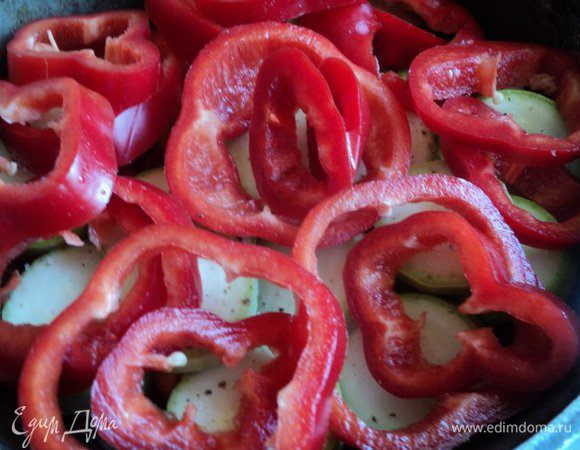Перец почистить от семян, порезать кольцами и положить на кабачки.