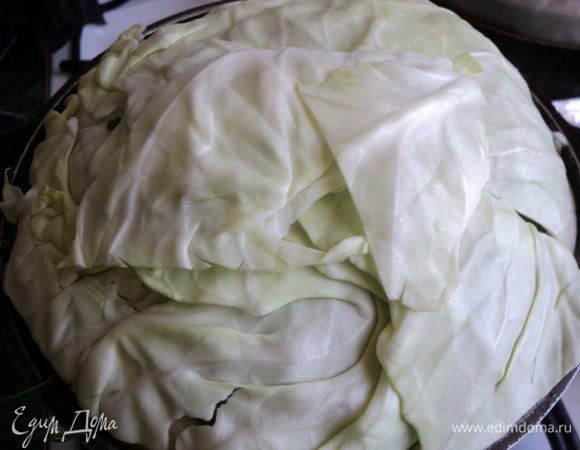 Сверху накрыть листьями капусты, закрыть крышкой. Для более плотного закрытия сверху можно поставить груз. Поставить на плиту, первые 20 минут тушить на сильном огне, затем температуру уменьшить до минимальной и тушить 1 час 10 мин.