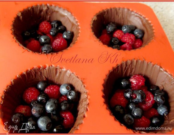 Достать шоколадные корзинки из формочек. Насыпать туда ягод, сверху - сливочный крем. Украсить ягодами и мятой.
