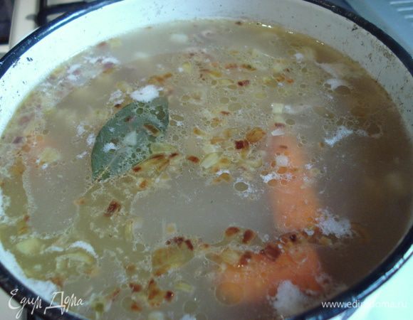 В бульон высыпаем крупу и варим до полуготовности, а затем кладем картофель, морковь и лавровый лист. На сливочном масле припускаем лук и огурцы, а потом отправляем в кастрюлю. Даем прокипеть минуты три.