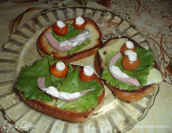 Теперь можно украшать.
Сделаем из черри глазки.Разрезав на две половинки.
Вырежем из колбасы рот.Майонезом нарисуем зрачки и язычок.


ПРИЯТНОГО АППЕТИТА!!!=)
