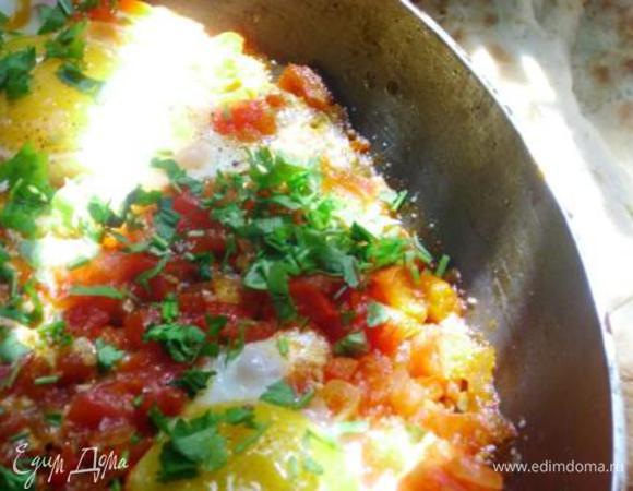 Посыпать рубленной зеленью. Подавать надо с питой или лепешкой в заранее подогретой посуде (лучше в керамической). Если положить шакшуку с огня на холодные тарелки – она немедленно свернется, опадет и потеряет половину вкуса (можно жарить и потом подавать в порционных сковородках).