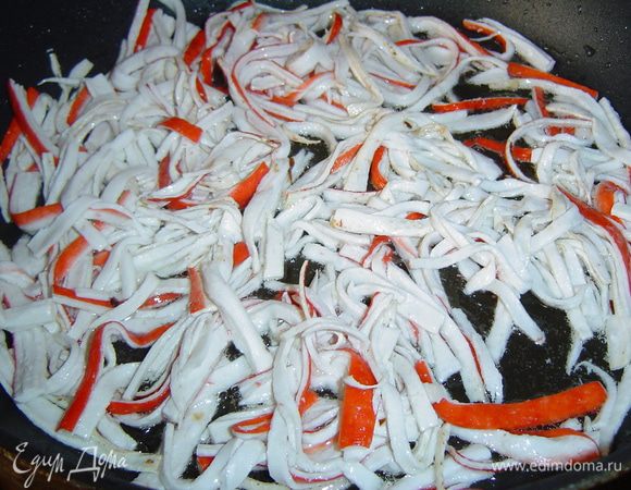 Крабовые палочки нарезаем соломкой и обжариваем на растительном масле.