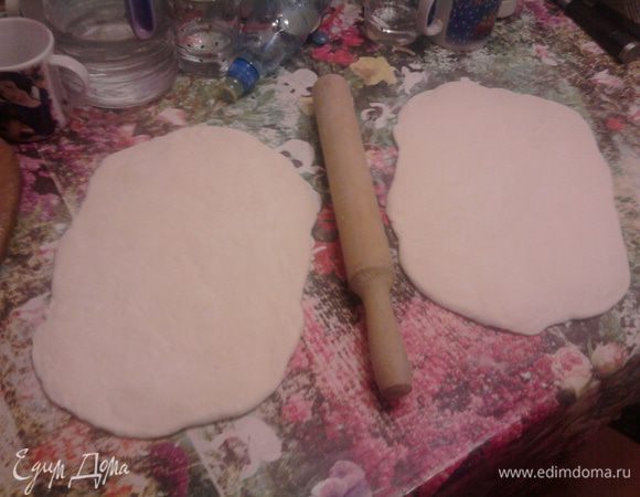 Когда тесто подойдет во второй раз, обмять его и разделить на 2 части. Раскатать.