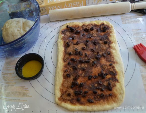 Выложим половину на приготовленную поверхность, сверху половины порции изюма.