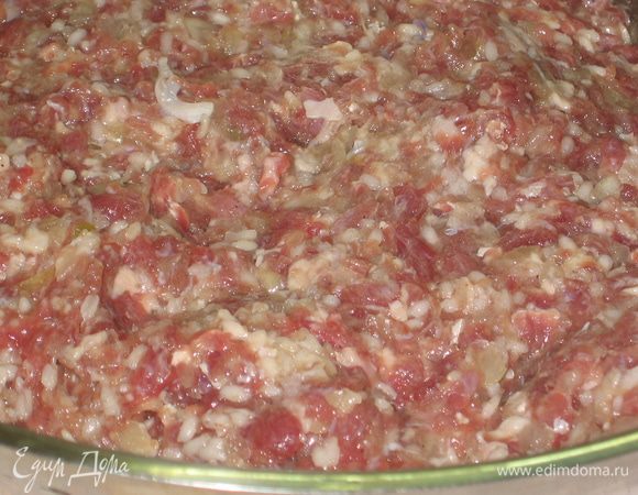 Приготовить начинку. Рис проварить минут 10 в большом количестве воды. Не доводите его до полной готовности. Мясо и лук провернуть через мясорубку. Промыть рис холодной водой и добавить к мясу. Добавить масло, соль, сахар и перец. Все тщательно перемешать.