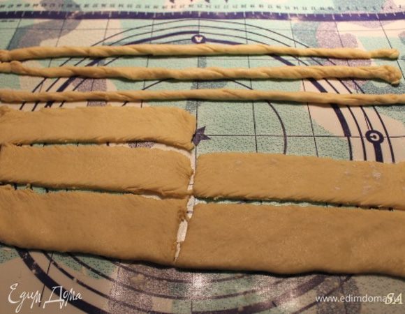 Оставшуюся треть теста раскатать немного, разрезать на 8 полосок шириной 2-3 см и длиной 10-12 см. Каждую полоску немного растянуть в руках и свернуть жгутом. Тесто легко растягивается, потому жгуты будут длинные. Каждый жгут обвалять в тростниковом сахаре.