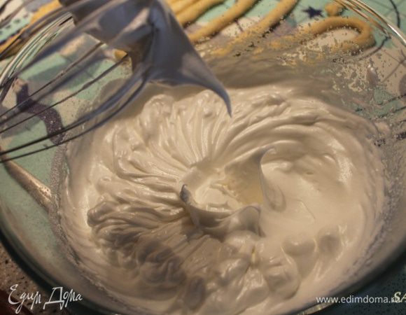 Приготовим белковое суфле. У нас оставались от теста 2 куриных белка, нужно добавить ещё один и взбить их в пышную пену. Постепенно ввести в массу ванильный сахар и сахарную пудру. Взбивать белки до устойчивых пиков. Выкладываем массу на персики, ровняем ложкой.