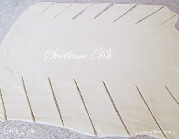 Тесто разморозить, раскатать в тонкий пласт и надрезать по краям.