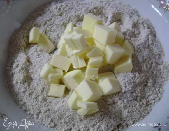 Для приготовления теста муку просеять в миску, добавить соль и нарезанное кусочками сливочное масло.