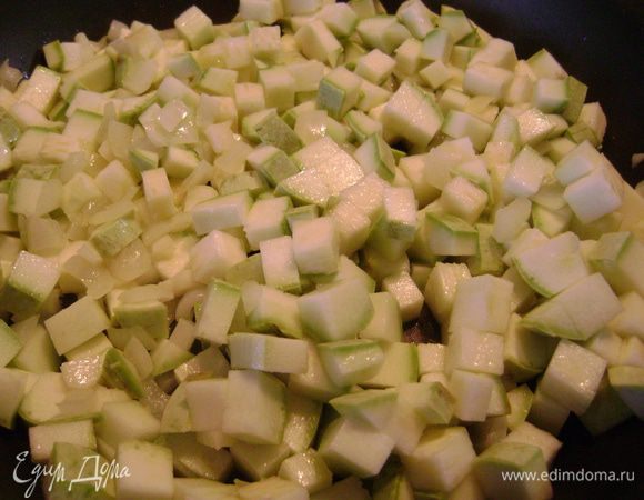 Затем добавить в сковороду кабачок, нарезанный кубиком. Потомить вместе с луком и чесноком ещё 10 мин.