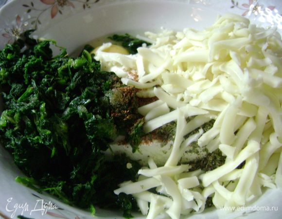 В большой миске смешать творог, яйца. Выложить туда мелко нарубленный шпинат (если размороженный, то отжать лишнюю влагу), 120 г натертого сыра. Посолить, поперчить, перемешать. Добавить кабачки с луком и ещё раз все перемешать.