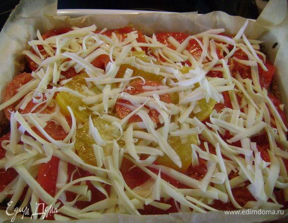 Вынуть форму из духовки, сверху разложить кружочки помидоров и посыпать оставшимся сыром. Выпекать в духовке ещё 20 мин.