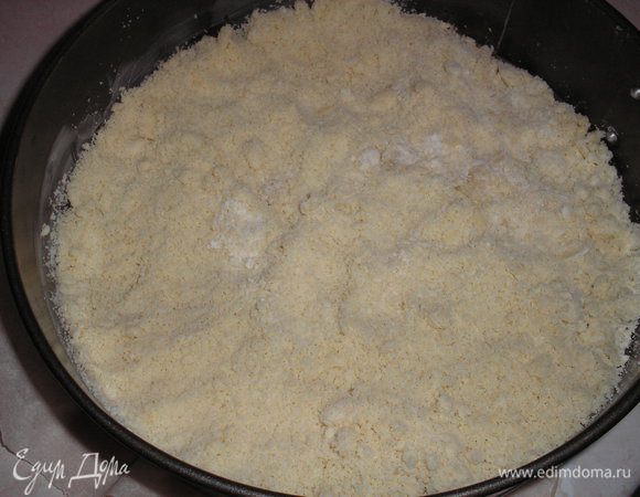 В форму для выпечки (диаметр 24 см) выкладываем крошки теста.





