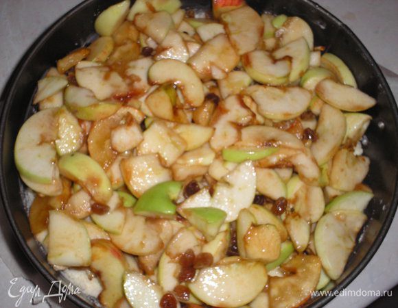 Далее на тесто выкладываем яблоки. Когда яблоки настаивались, образовался сироп, им тоже поливаем яблоки, несколько ложек оставляем.