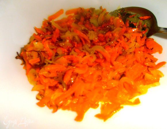 Натираем на крупной тёрке морковь и обжариваем её с нарезанным репчатым луком в растительном масле. Выкладываем в блюдо для салата.