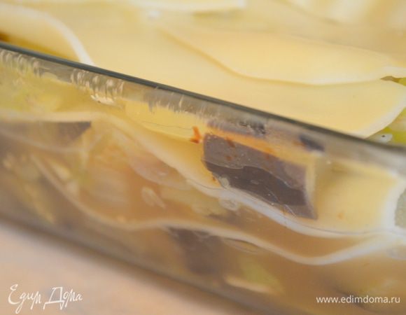 Выложить слоями овощи и листы лазаньи в форму, смазанную маслом. первый слой овощи, а верхний - листы лазаньи.