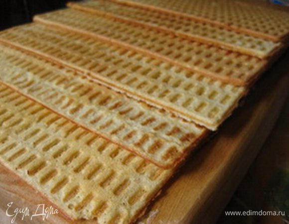 Вафельницу слегка смазать маслом и испечь одну за другой вафли (каждая вафля - это приблизительно 2 ст.ложки теста). Готовым вафлям дать остыть.