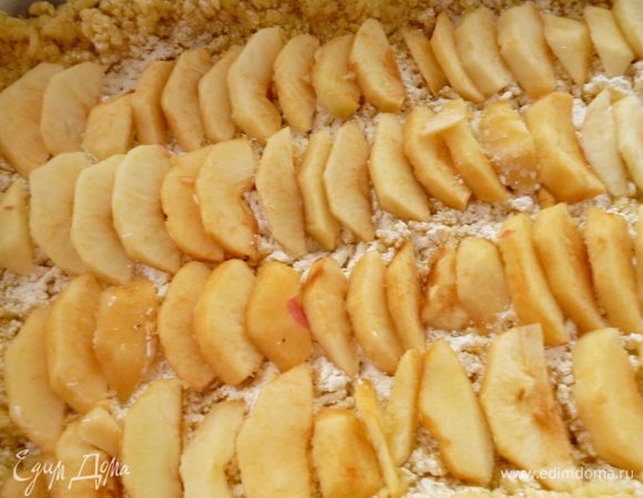 Выкладываем слой почищенных от кожицы и нарезанных дольками яблок. По желанию яблоки можно слегка присыпать сахаром.