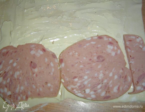 Нарезаем тонко вареную колбасу и выкладываем на тесто.