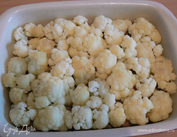 Выкладывать на фарш, слегка вдавливая в него, букетики цветной капусты (капусту предварительно слегка отварить в подсоленной воде)